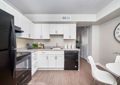 A modern kitchen featuring sleek white cabinets paired with stylish black appliances, creating a contemporary aesthetic.